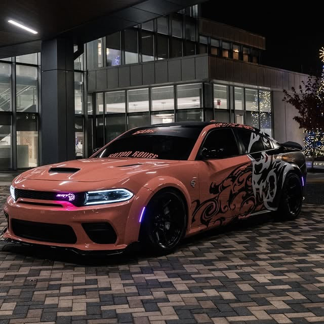 Custom black and white Hellcat demon side decal on a coral widebody Dodge Charger at night, designed by JCD