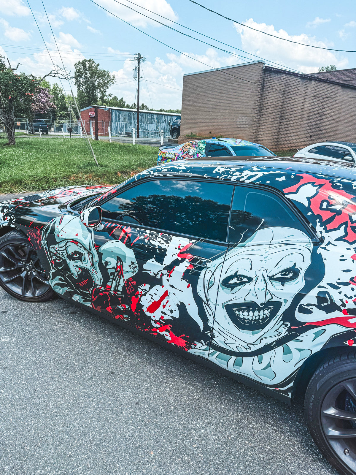 Side detail of a hand-drawn character show wrap on a Dodge Challenger