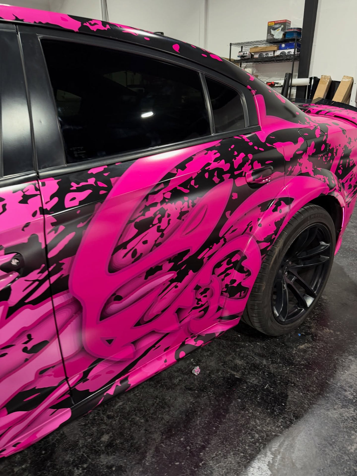 Detail of the pink and black abstract wrap artwork on a Dodge Charger Hellcat